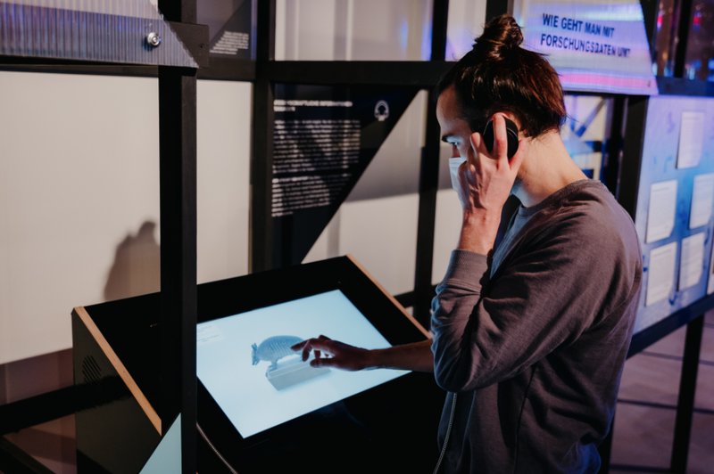 Ein Mann hört sich an, wie Sammlungsstücke am Museum für Naturkunde digitalisiert werden.